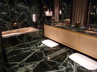 Spacious Presidential Suite bathroom at the Omni Mandalay, with marble walls and floor with hot tub and shower